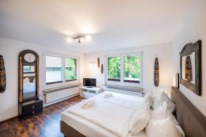 a bedroom with a large bed and two windows at Oma's Küche & Quartier in Binz