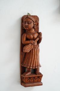 uma estátua de madeira de uma mulher numa parede em Villa Kai em Trou dʼEau Douce