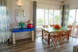 uma sala de jantar com uma mesa azul e cadeiras em Villa Kai em Trou dʼEau Douce