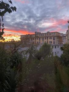 - une vue sur un bâtiment avec un coucher de soleil en arrière-plan dans l'établissement Charmante chambre privée 5/10 mn du CentreVille/Port-Jardin/Parking, à Nice