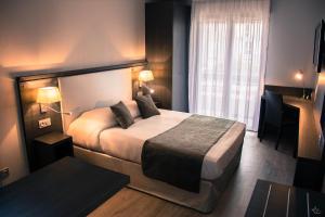 ein Hotelzimmer mit einem Bett und einem Fenster in der Unterkunft Séjours & Affaires Aix-en-Provence Mirabeau in Aix-en-Provence