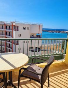 a balcony with a table and chairs and the ocean at Cristianos in Los Cristianos