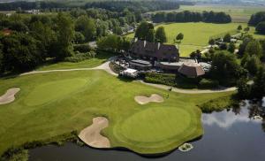 - une vue aérienne sur un parcours de golf avec une maison dans l'établissement Vakantiewoning Dorp-28, à Hollebeke