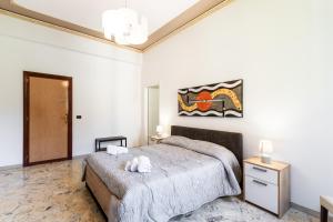 sypialnia z łóżkiem i obrazem na ścianie w obiekcie Le Torrette Rooms and Apartments w mieście Avola
