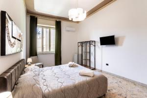 a bedroom with a bed and a couch and a television at Le Torrette Rooms and Apartments in Avola