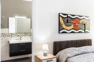 bagno con letto, lavandino e specchio di Le Torrette Rooms and Apartments ad Avola