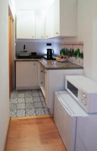 a kitchen with white cabinets and a white microwave at Czar Prowansji - Comfy & Quiet near Rynek&Train Station in Krakow