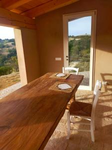 uma mesa de madeira e cadeiras num quarto com uma janela em B&B Villa Arcadia em Saludecio