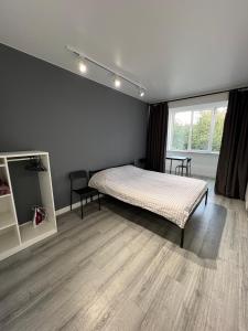 Schlafzimmer mit einem Bett und einem Fenster in der Unterkunft Smart Modern loft apartments in Iwano-Frankiwsk