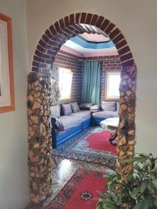 - un salon avec un canapé sous un mur de briques dans l'établissement Maison bord de mer, à Zaouia Sidi Ouaggag