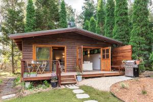 a log cabin with a porch and a grill at Crabapple Cabin in Bowral
