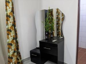 a bathroom with a black dresser and a mirror at Mama Africa Luxury in Moshi