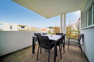 une table et des chaises sur le balcon d'une maison dans l'établissement Appartement lumineux, 80m², proche des Vosges, à Thann