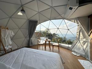 um quarto com uma grande janela de vidro com uma cama. em Arabica lodge em Ban Huai Khai
