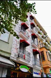 イスタンブールにあるサンタフェ ホテルの通りに面した白い建物で、バルコニーと窓が付いています。