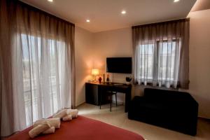 a bedroom with a bed and a desk and a television at BnB Villa Langellotti in Pompei