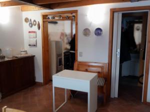 una habitación con una mesa blanca y una puerta en Terratetto 90 mtq 10 posti letto en SantʼAnna Pelago