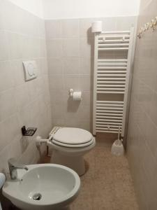 a bathroom with a white toilet and a sink at Terratetto 90 mtq 10 posti letto in SantʼAnna Pelago