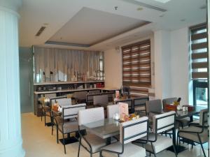 un restaurante con mesas y sillas y una cocina en A25 Hotel - Hoàng Đạo Thuý, en Hanói