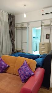 - un salon avec un canapé et des oreillers dans l'établissement Regalia Suite Studio, à Kuala Lumpur