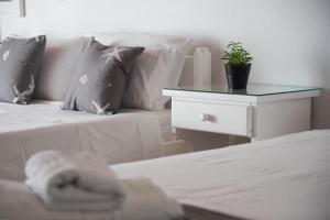 a bedroom with a bed and a table with a plant on it at Fisilanis Beachfront Hotel in Logaras