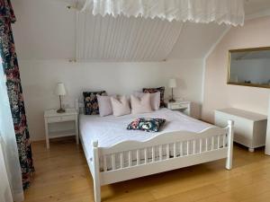 um quarto com uma cama branca com almofadas e um espelho em Appartement Resch em Mariapfarr