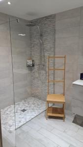 una doccia con sedia in legno in bagno di Chez Grégory et Nadine a Houssen