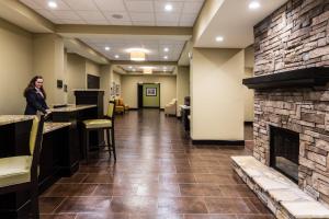 a woman standing in a lobby with a fireplace at Staybridge Suites Atlanta Airport in Atlanta