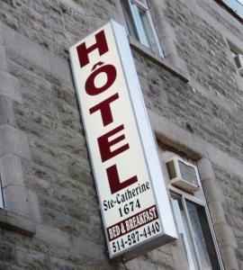 a sign for a hotel on the side of a building at Hotel Ste-Catherine in Montréal