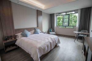 Un dormitorio con una cama grande y una ventana en NATIONAL SCENIC SPOT SUNSHINE RESORT HOTEL, en Zhangjiajie