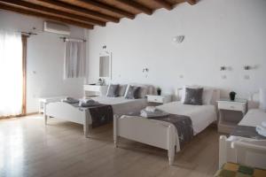 a white room with two beds and a couch at Fisilanis Beachfront Hotel in Logaras