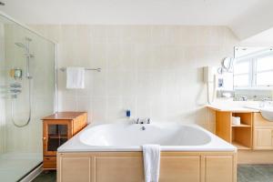 a bathroom with a tub and a shower and a sink at The Lovat, Loch Ness in Fort Augustus +37 photos