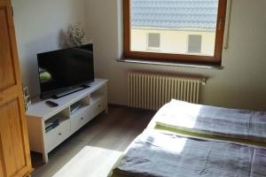 a bedroom with a television on a white dresser at Ferienwohnung Schwörer bis 7 Personen in Rheinhausen