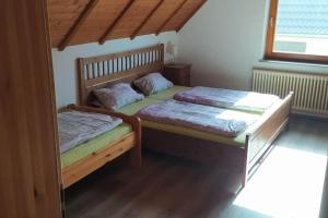 two beds in a room with wooden floors at Ferienwohnung Schwörer bis 7 Personen in Rheinhausen