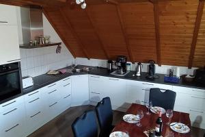 a kitchen with white cabinets and a table and chairs at Ferienwohnung Schwörer bis 7 Personen in Rheinhausen