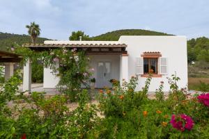 a white house with flowers in front of it at Villa Can Portmany in Sant Josep de sa Talaia