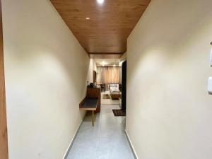 un corridoio con pareti bianche e soffitto in legno di Hotel Rockbay-near sea beach & temple a Puri