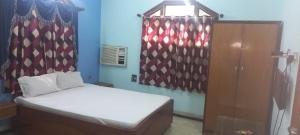 niewielka sypialnia z łóżkiem i szafką w obiekcie HOTEL SHYAMALI AND EVENTS w mieście Dhanbad