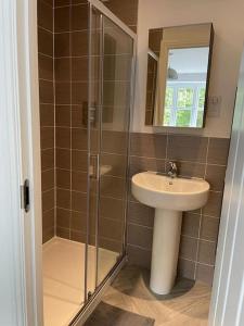 a bathroom with a sink and a shower at Crib Coed in Old Colwyn