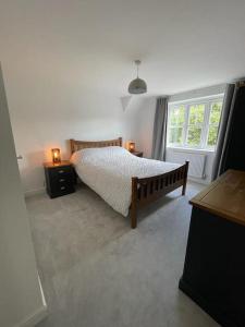 a bedroom with a bed and two tables with lamps at Crib Coed in Old Colwyn