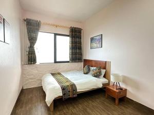 ein Schlafzimmer mit einem großen Bett und einem Fenster in der Unterkunft Misty House Sapa in Sa Pả
