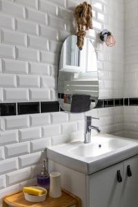 a white bathroom with a sink and a mirror at Les Fauvelles Paris La Défense in Courbevoie