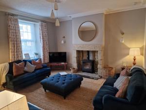 a living room with a couch and a fireplace at Coral Cottage Amble in Amble