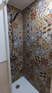 y baño con ducha y pared de azulejos. en Apartamento Jerez Centro, en Jerez de la Frontera