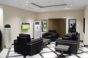 a waiting room with couches and chairs in a lobby at Ellyxville Hotel in Lekki