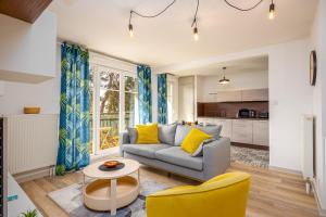 a living room with a couch and a table at Le 24-GregIMMO-Appart'Hôtel in Belfort