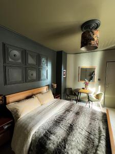 a bedroom with a large bed and a table at La Chambre des Trois Églises in Riquewihr