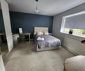a bedroom with a bed and a desk and a window at Polkerris Way 1 in Fleet