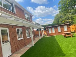 a yard of a brick house with a lawn at Polkerris Way 1 in Fleet