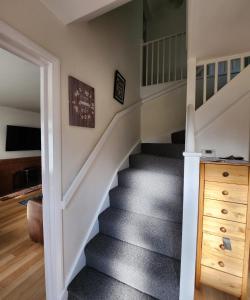 uma escada numa casa com escadas alcatifadas cinzentas em Polkerris Way 1 em Fleet